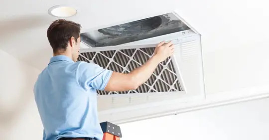 Man replacing AC vent filter