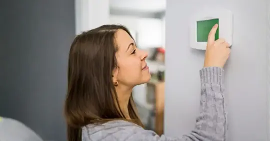 Woman set the thermostat at house